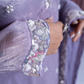 Close-up of a lavender dress with intricate beadwork on the sleeves.