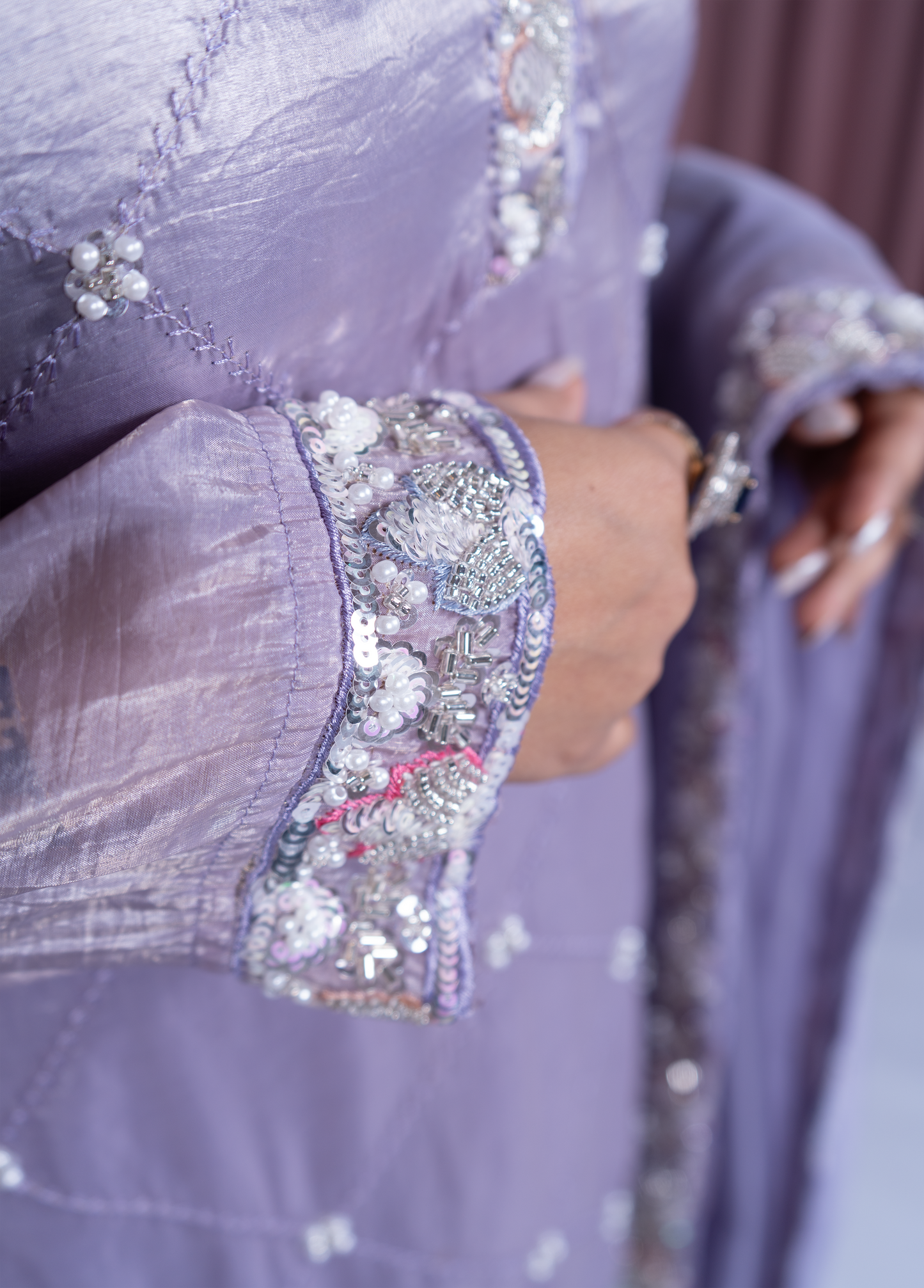 Close-up of a lavender dress with intricate beadwork on the sleeves.