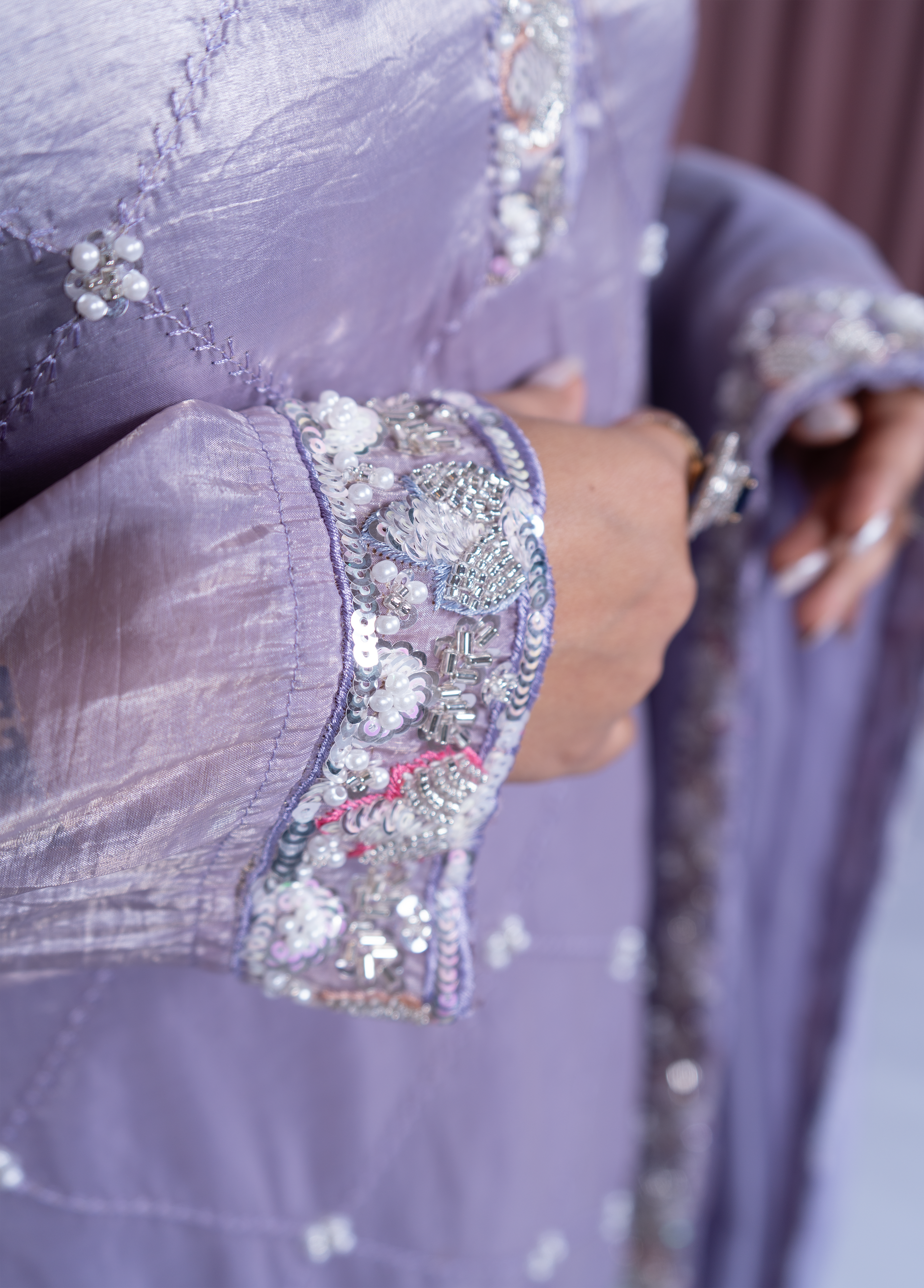 Close-up of a lavender dress with intricate beadwork on the sleeves.