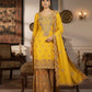 Woman in a yellow and gold traditional outfit standing in an elegant room.