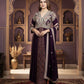 Woman in a traditional outfit standing in an ornate room with decorative walls and furniture.