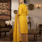 Woman in a yellow traditional outfit with a patterned dupatta in an elegant room.