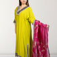 Woman wearing a green traditional outfit with a pink dupatta on a white background
