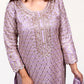 Woman wearing a purple embroidered dress with gold details on a white background
