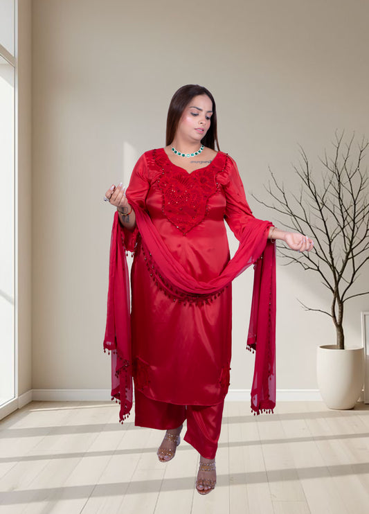 Woman in a red traditional outfit standing in a room with a neutral color scheme.