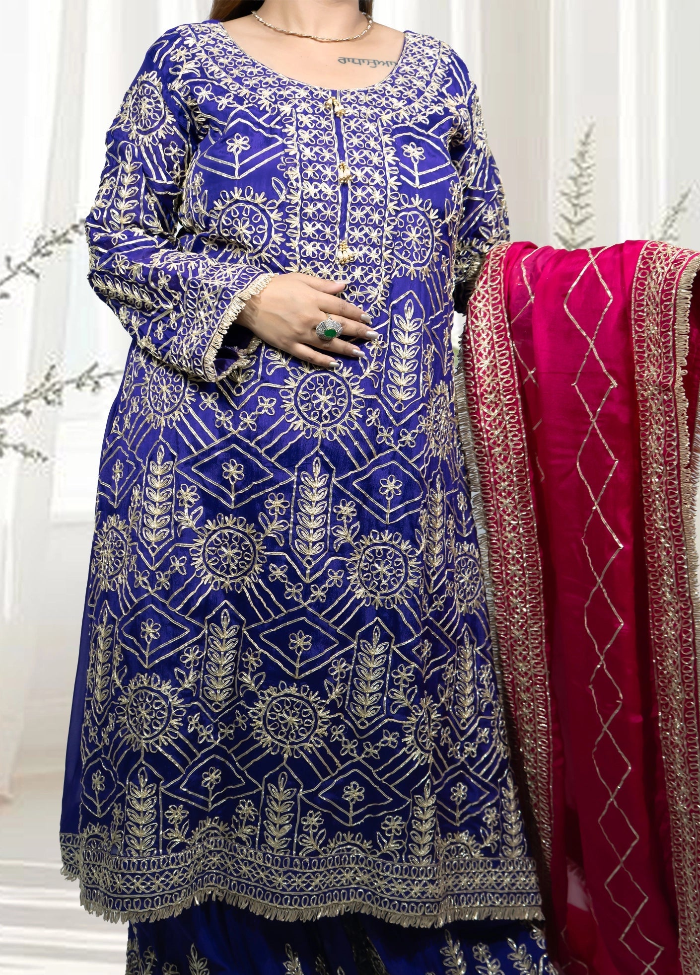 Blue embroidered traditional outfit with a pink dupatta on a white background