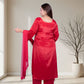 Woman in a red traditional outfit standing in a room with a neutral background