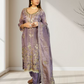 Woman wearing a traditional embroidered outfit in a minimalistic room.