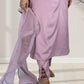Person wearing a light pink traditional outfit with a sheer dupatta, standing on a white floor.