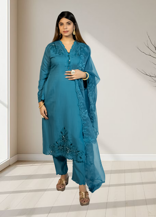 Woman wearing a blue traditional outfit with embroidery in an indoor setting