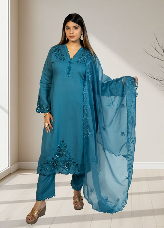 Woman wearing a blue embroidered outfit with a matching dupatta indoors.