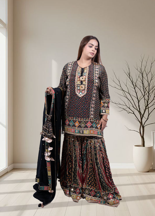 Woman wearing a traditional outfit with intricate patterns in a well-lit room.