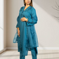 Woman wearing a blue traditional outfit with intricate designs indoors.