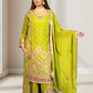 Woman wearing a green embroidered traditional outfit with a matching dupatta in a well-lit room.
