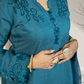 Blue embroidered dress with intricate detailing on a neutral background