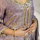 Purple embroidered garment with gold detailing worn by a person.