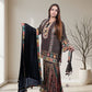 Woman holding a traditional outfit with a decorative shawl in a well-lit room.
