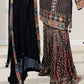 Traditional outfit with a patterned top and black skirt on a white floor.