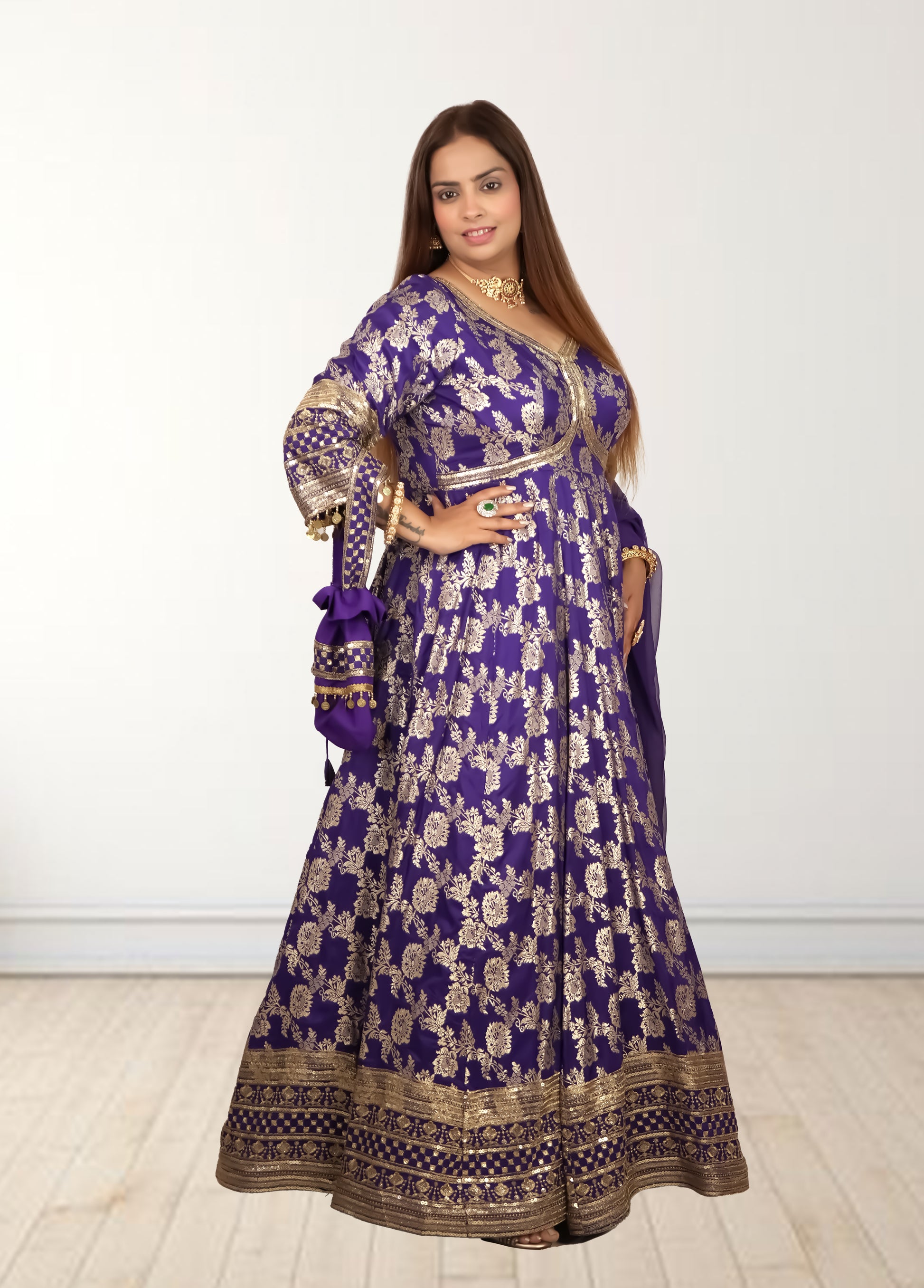 Woman wearing a purple and gold traditional outfit on a white background