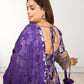 Woman wearing a purple traditional outfit with gold embroidery on a white background