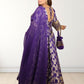 Woman wearing a purple saree with gold patterns on a white background