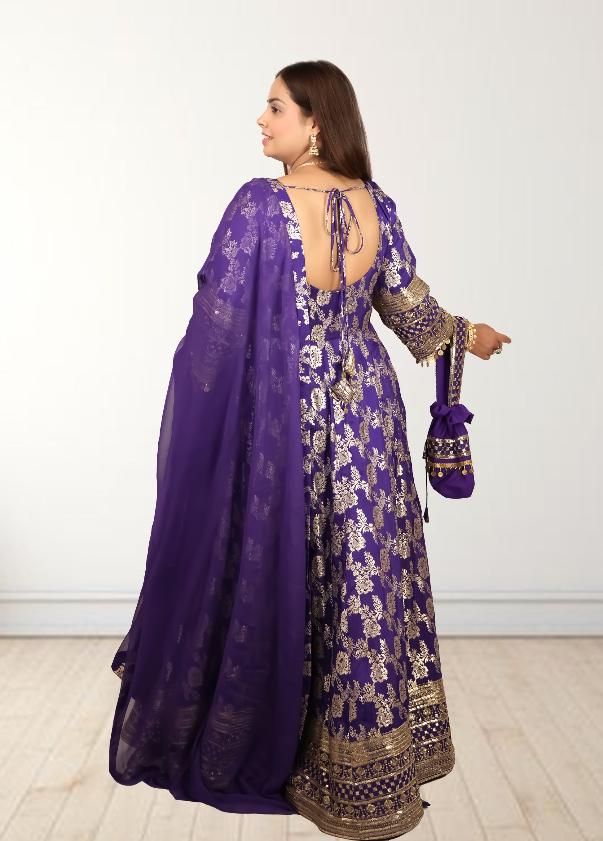 Woman wearing a purple traditional outfit with floral patterns on a white background