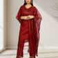 Woman wearing a red lace outfit standing indoors with a neutral background