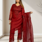 Woman wearing a red traditional outfit with a matching dupatta in a minimalistic setting.