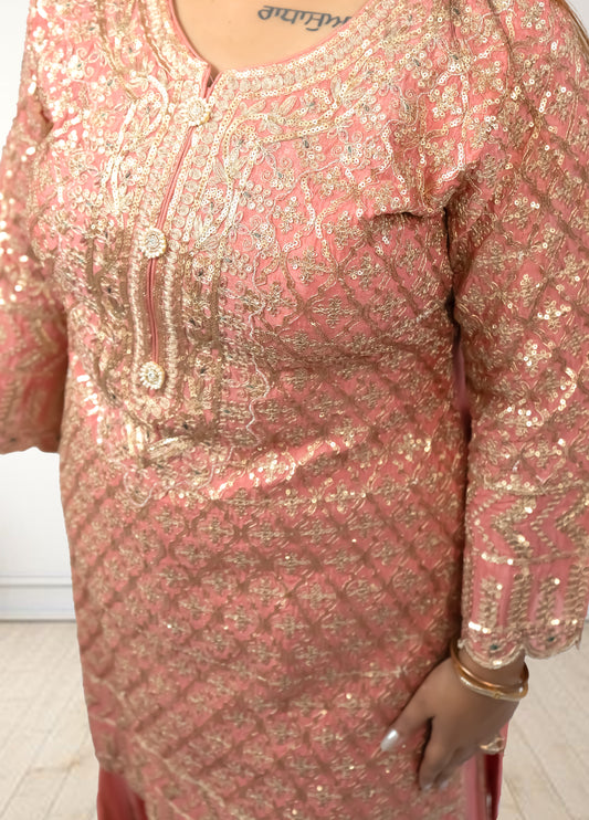 Pink and gold embroidered dress with a plain background