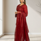 Woman wearing a red traditional outfit in a minimalistic room.