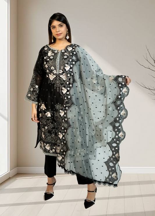Woman holding a black and white embroidered dupatta in a neutral setting