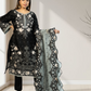 Woman holding a black embroidered outfit with a matching dupatta in a minimalistic setting