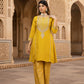 Woman in a yellow traditional outfit standing in an architectural setting