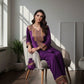 Woman in a purple traditional outfit sitting on a chair in a well-lit room.