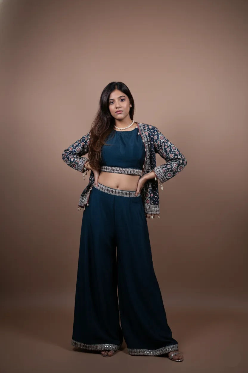 Woman wearing a dark blue outfit with a patterned jacket against a brown background