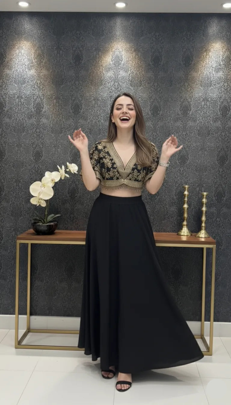 Woman in a black and gold outfit standing in a room with decorative wall and table.