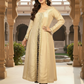 Woman in a beige traditional outfit standing in an ornate architectural setting.