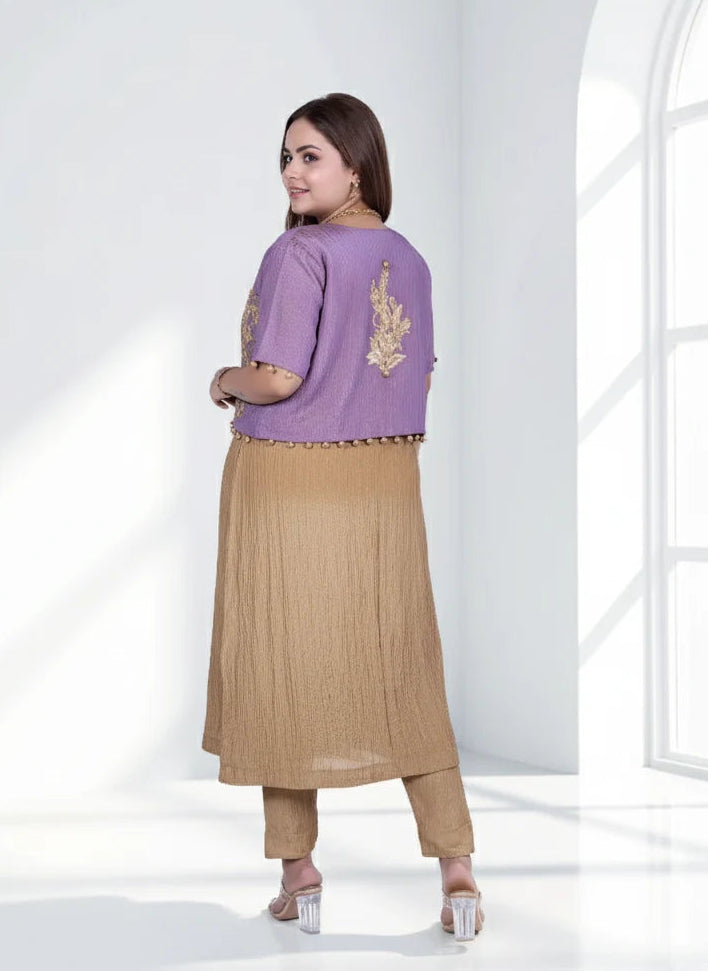 Woman wearing a purple top with gold embroidery and beige skirt in a bright room.