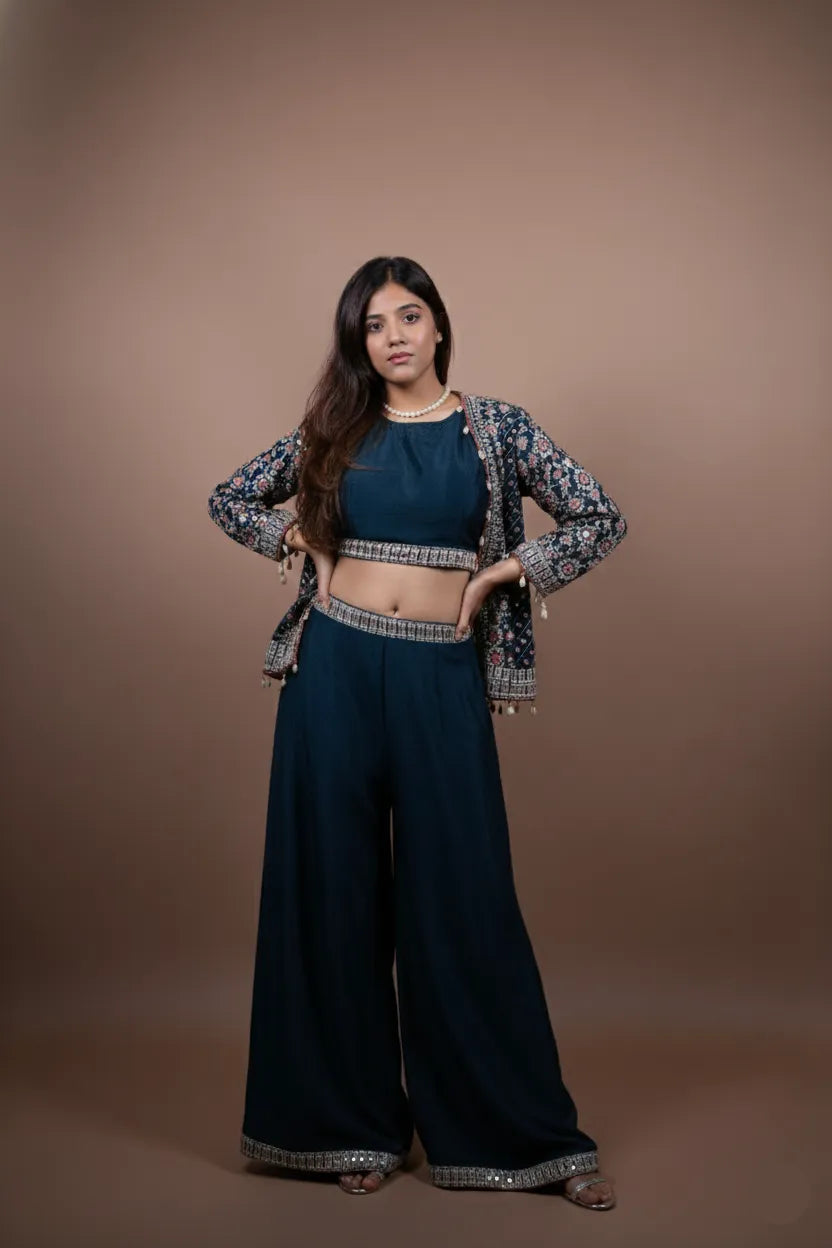 Woman wearing a traditional outfit with a floral jacket and dark pants on a brown background