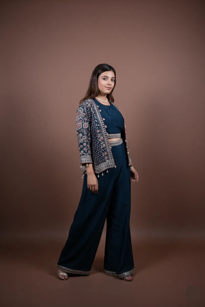 Woman wearing a dark blue outfit with a patterned cardigan against a brown background