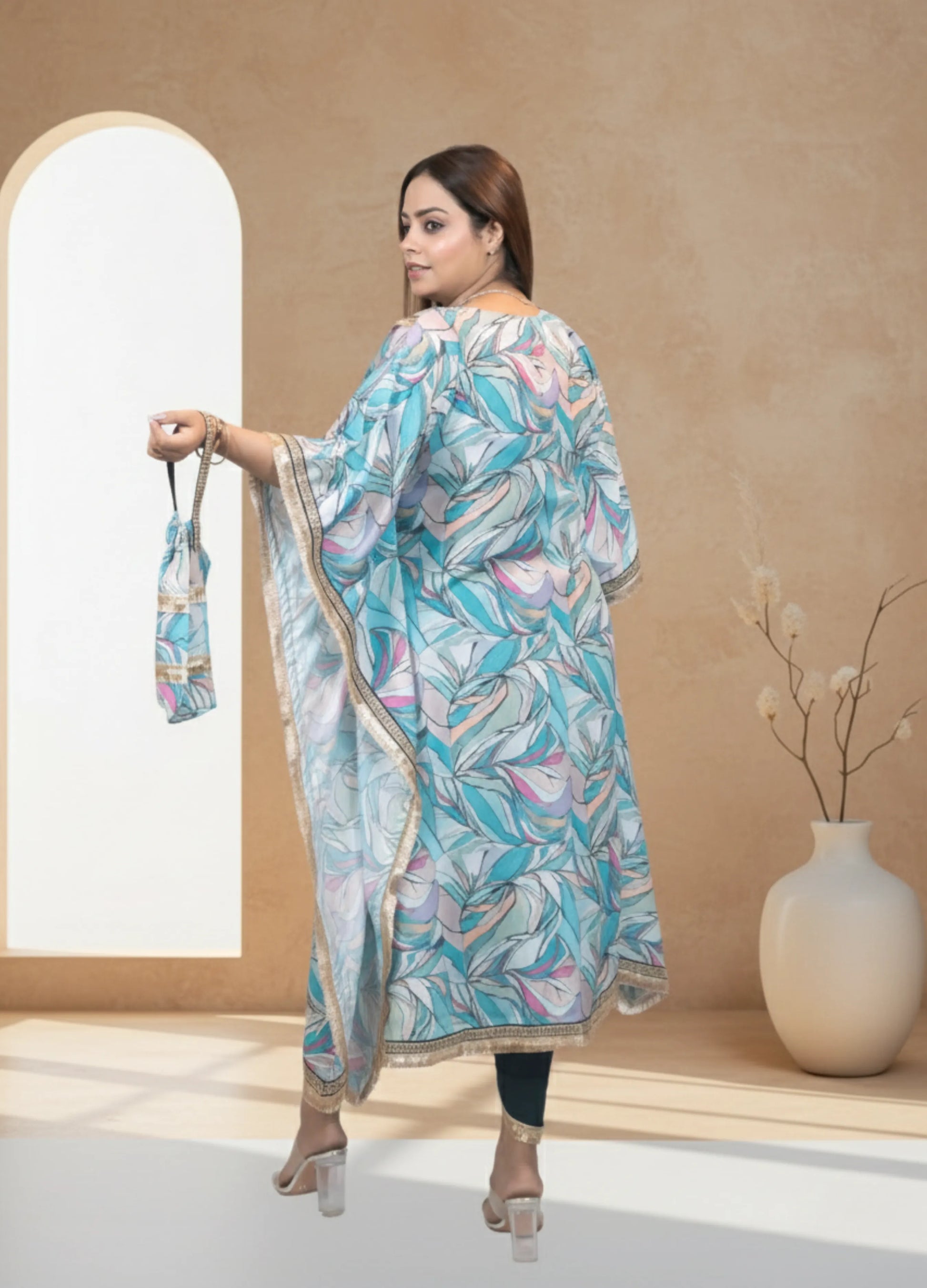 Woman in a floral dress holding a matching bag in a minimalistic setting