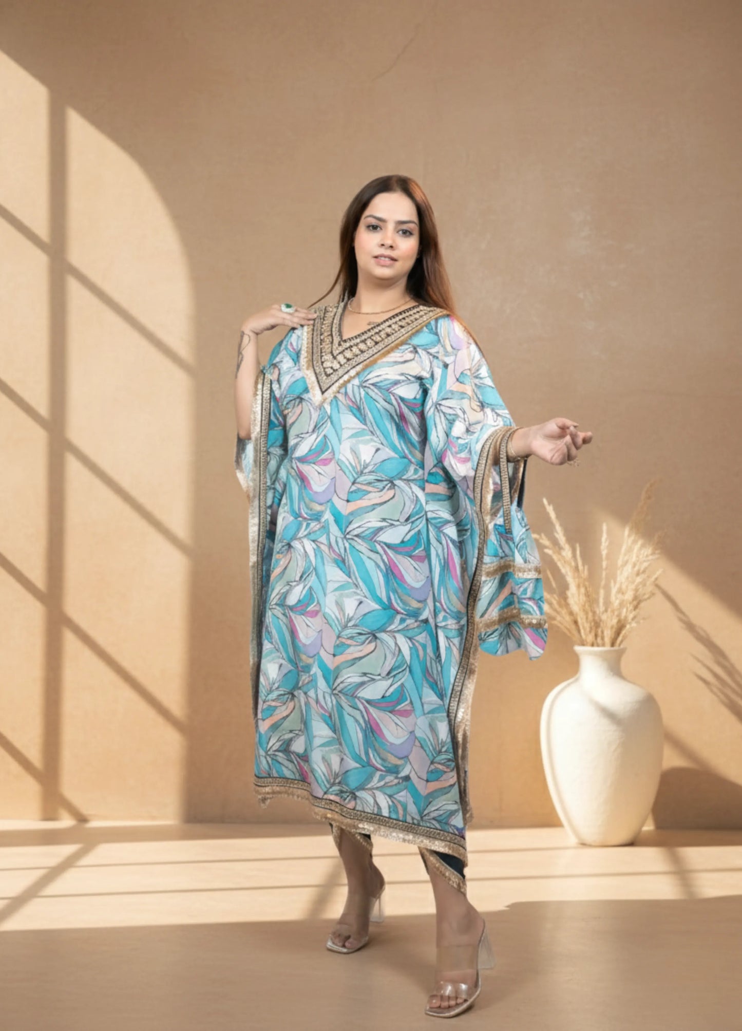 Woman wearing a patterned dress with a beige wall and vase in the background
