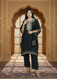 Woman in black traditional outfit with embroidery standing in a decorative archway.
