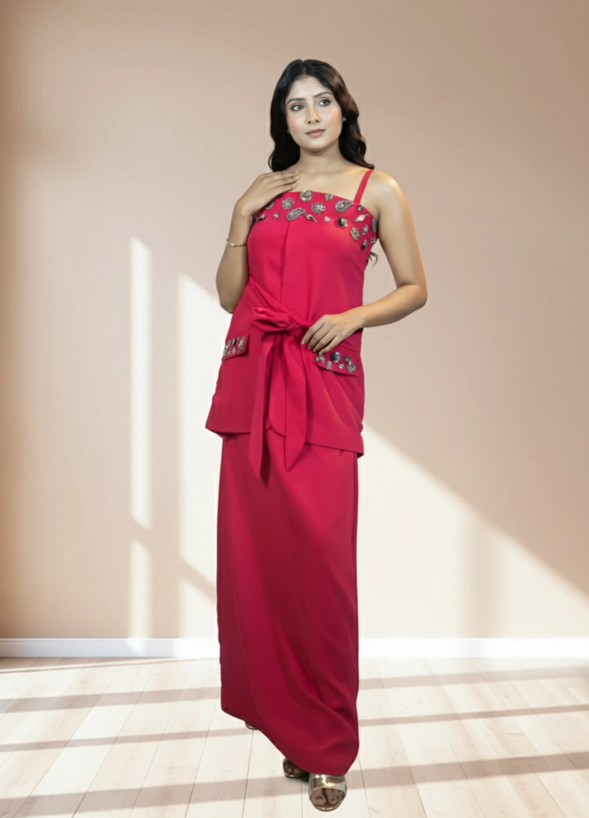 Woman wearing a red dress with floral embellishments on a beige background