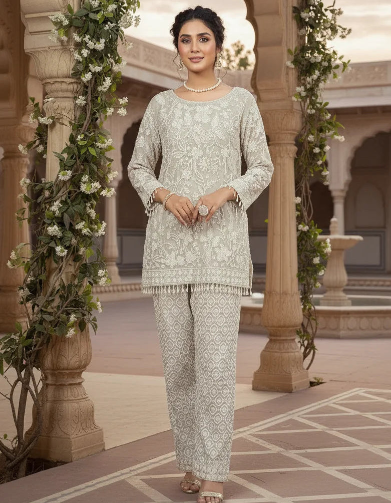 Woman in a traditional outfit standing in an ornate courtyard with floral decorations.