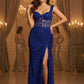 Woman in a blue evening gown with a high slit in a formal setting