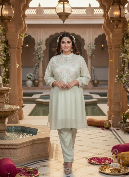 Woman in traditional attire standing in an ornate indoor setting with arches and decorative elements.