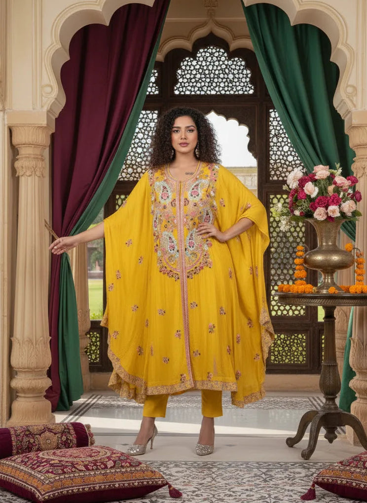 Woman in a yellow traditional outfit standing in an ornate room with decorative elements.
