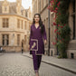 Woman in a purple traditional outfit walking on a cobbled street with floral decorations.