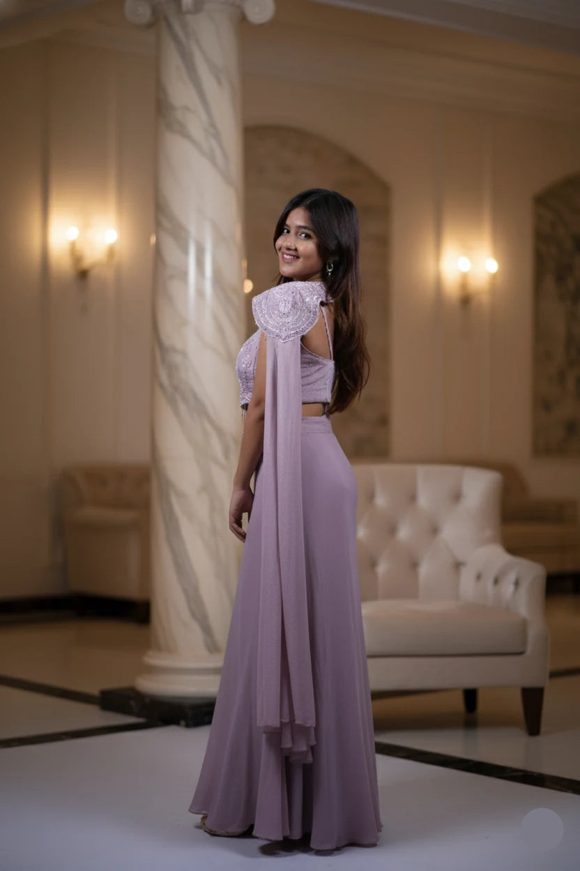 Woman in a lavender outfit standing in an elegant indoor setting
